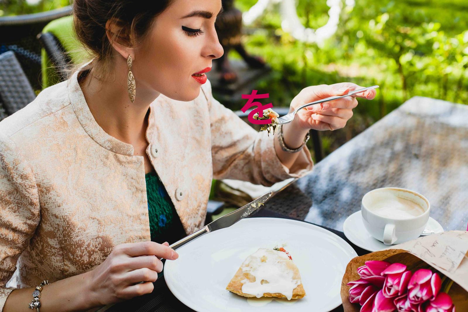 A young woman eating a slice of pie, thus demonstrating what the Japanese particle を that marks direct objects is used for.