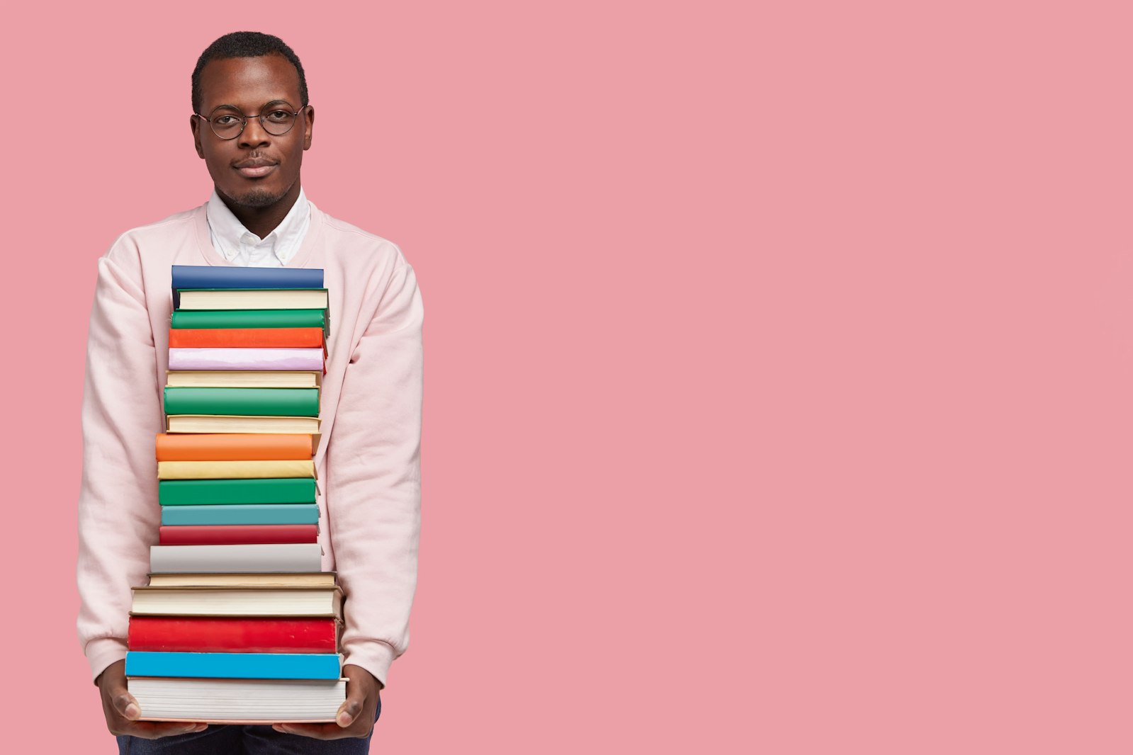 A photo of a man holding several textbooks; the header image for a blog article about Japanese textbooks.