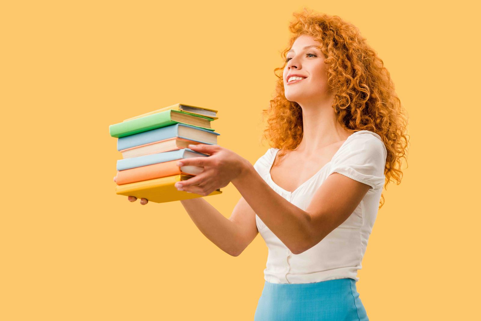 A photo of a young woman holding several textbooks; the header image for a blog article about Japanese textbooks.