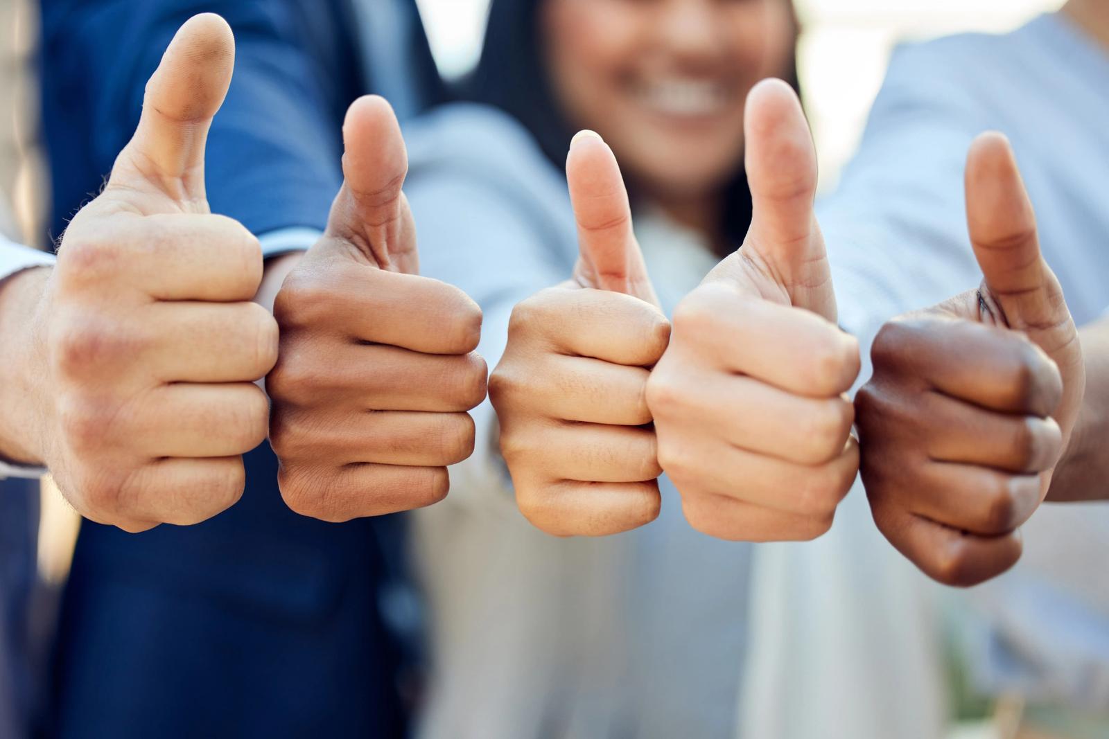 Several people with their thumbs up, showing the global signal for "yes"