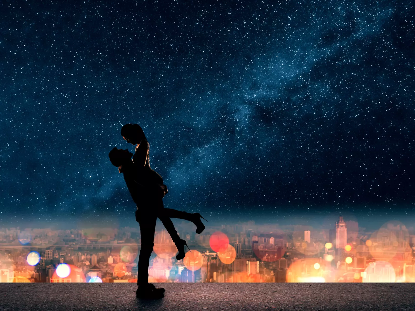 Nightscape of city lights with a silhouette of a couple