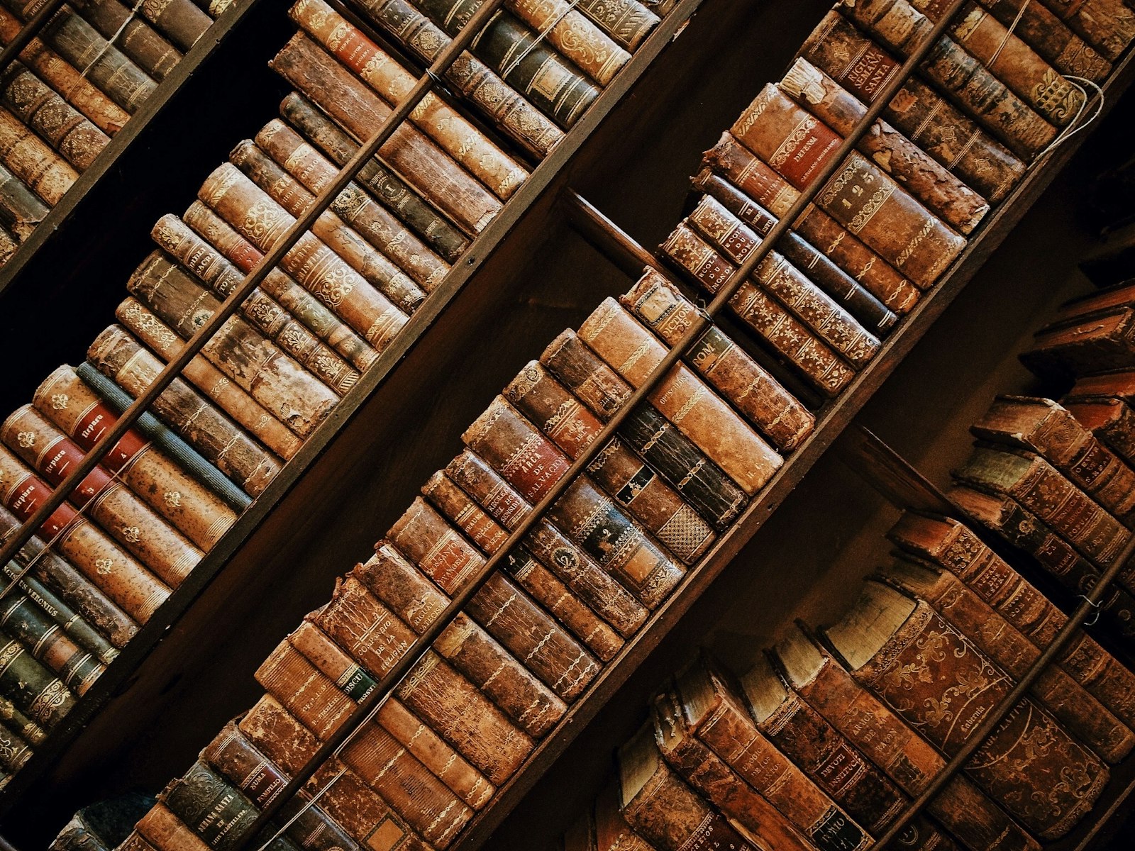 A series of shelves with old books in diagonal orientation.