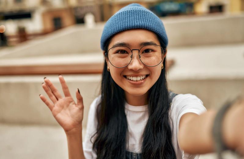 A young woman waving at the camera—hello!