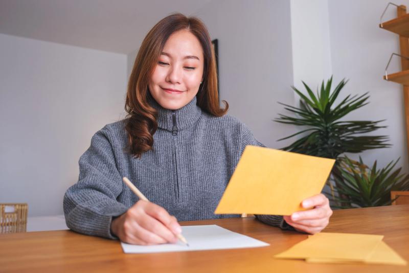 A young Japanese woman writing a letter.