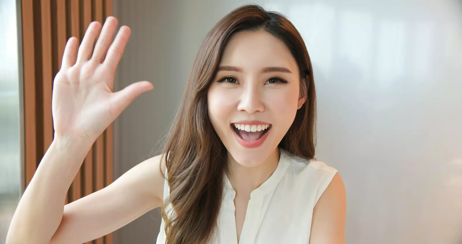 An asian woman waving hello