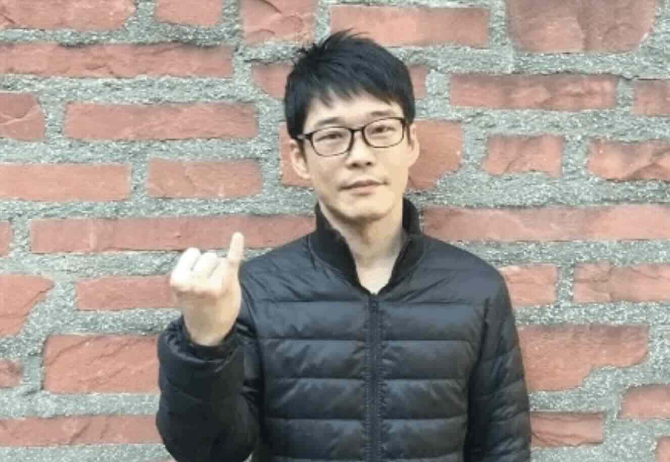 A Japanese man holding up his pinky finger, a Japanese gesture that means you have a romantic partner.