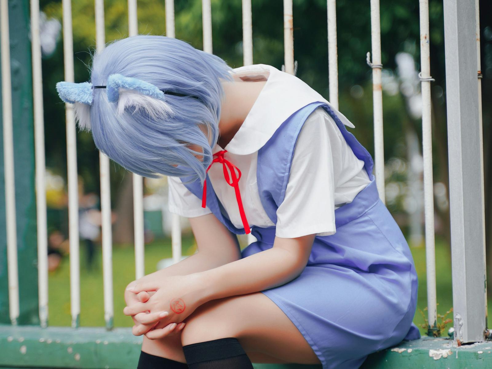 A person dressed in cosplay with their head down, pleading.