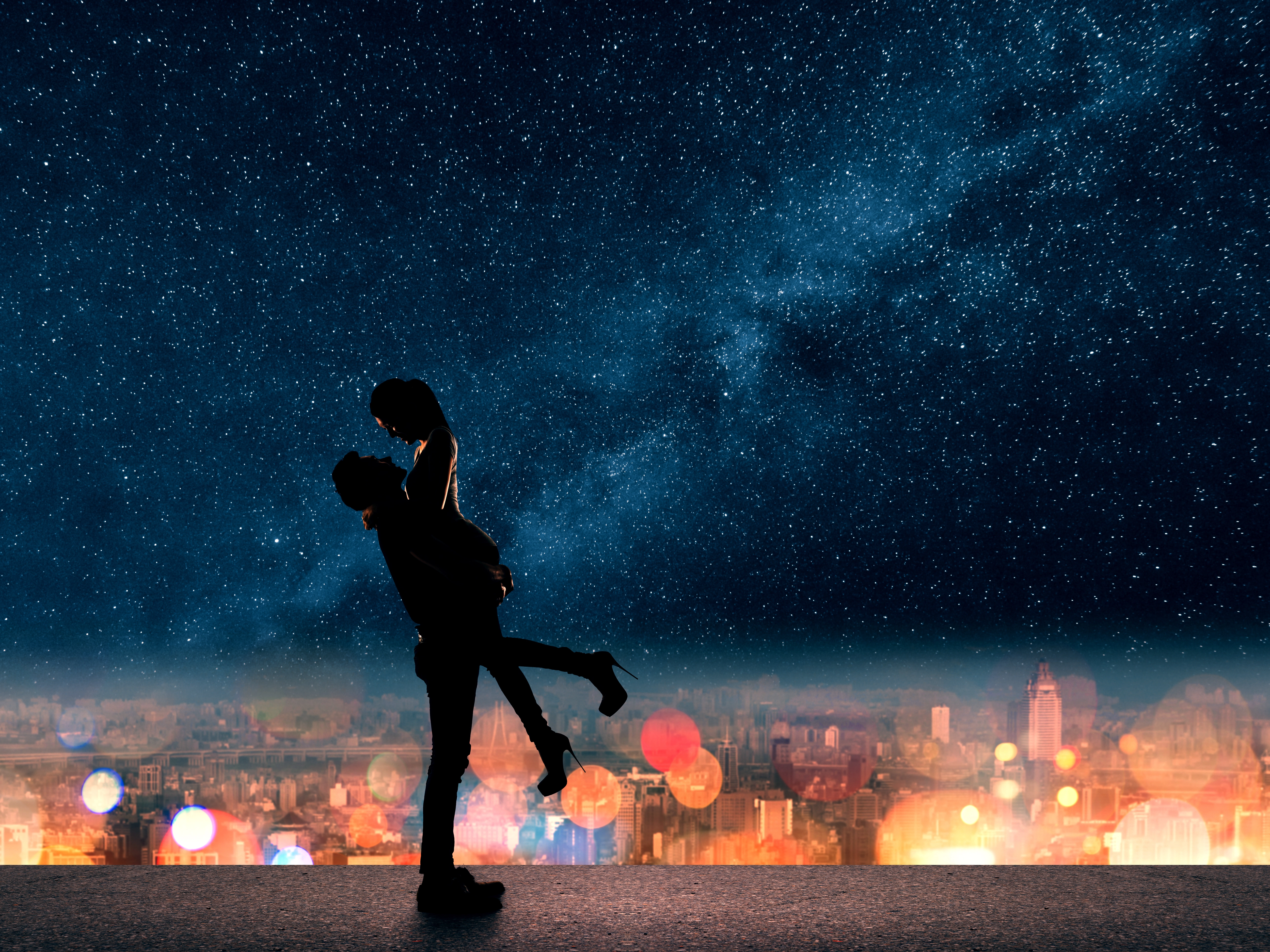 Nightscape of city lights with a silhouette of a couple
