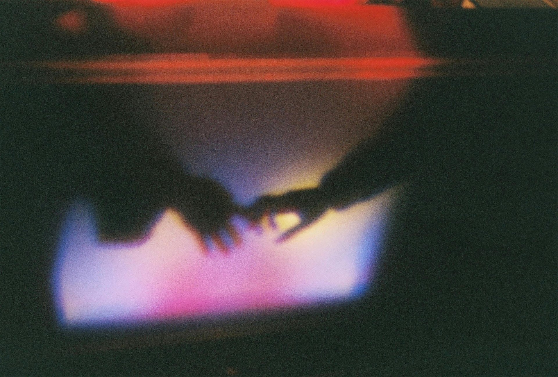A blurry image of a fleeting moment in which two people take each other's hands