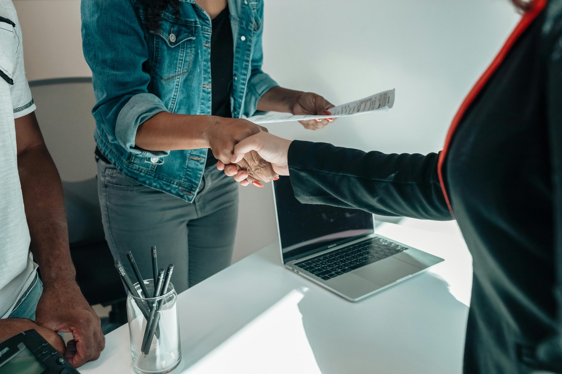 Two people shaking hands, a non-verbal way to say 'that's right' or 'precisely' in English